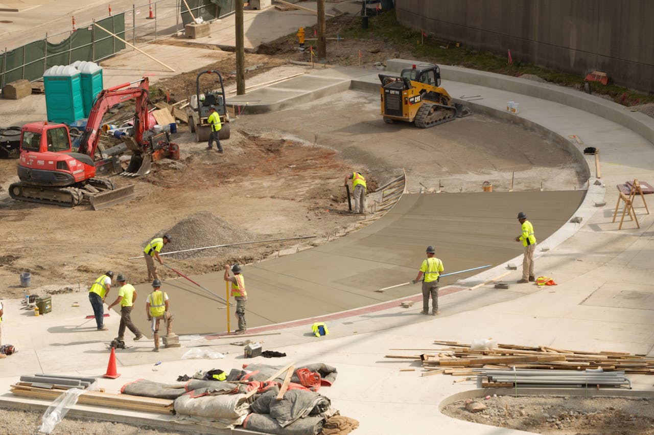 services-02 Construction workers paving concrete at a bustling site in Covington, KY.