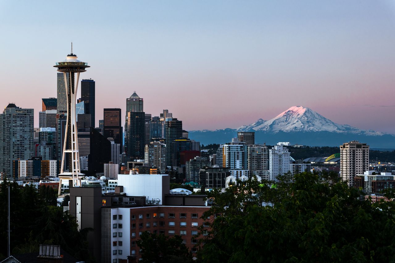 Captivating view of Seattle's skyline featuring the Space Needle and Mount Rainier at dawn.