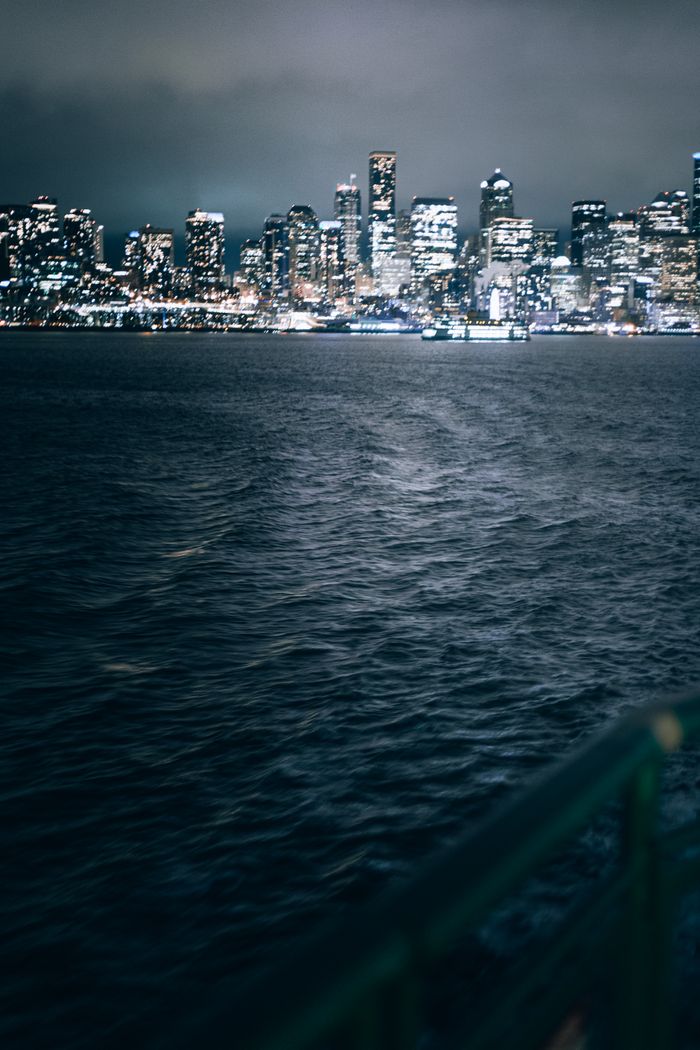 gallery-02 Moody view of the Seattle skyline at night from the waterfront, capturing urban lights.